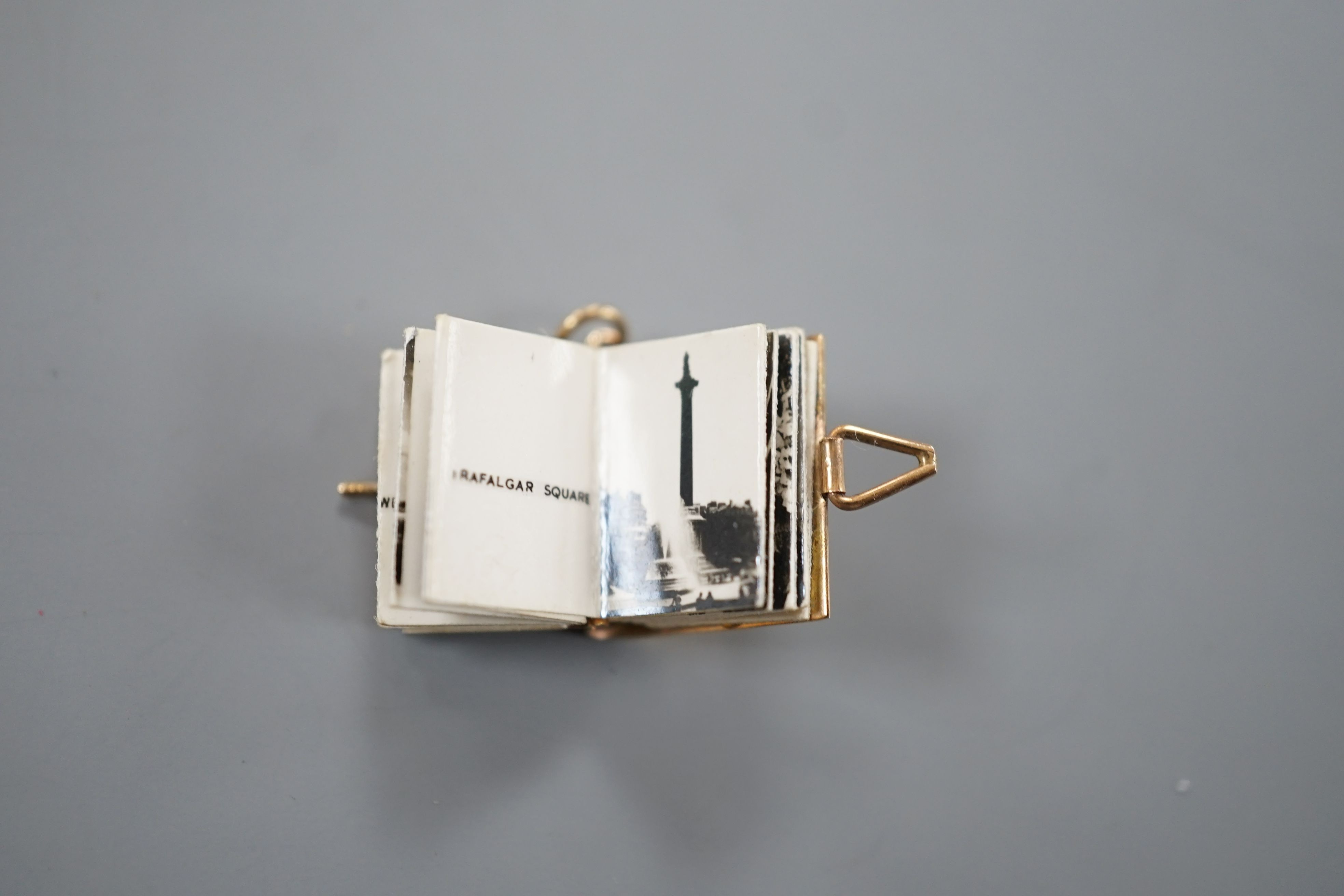 An enamelled 9ct gold photograph album charms with views and crest of London, 1.5cm gross 3.1 grams